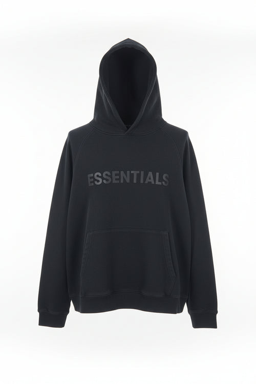 Folded black hoodie with 'ESSENTIALS' text on a patterned surface